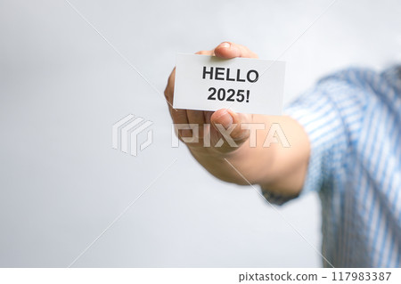 Man holding a white card with Hello 2025. Man holding a white card with Hello 2025. 117983387