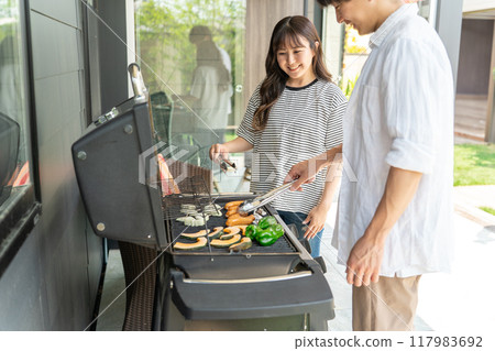 Men and women having barbecue, camping, BBQ, grilled meat, glamping (home party, balcony camping) Men and women having barbecue, camping, BBQ, grilled meat, glamping (home party, balcony camping) 117983692