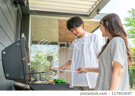 Men and women having barbecue, camping, BBQ, grilled meat, glamping (home party, balcony camping) Men and women having barbecue, camping, BBQ, grilled meat, glamping (home party, balcony camping) 117983697