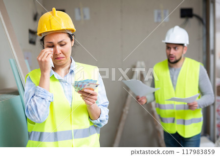 Woman builder crying because of low wages 117983859