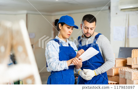 Builders determining scope of work in building under renovation 117983897