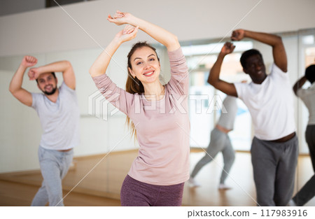 Young woman enjoying active dancing in dance studio 117983916