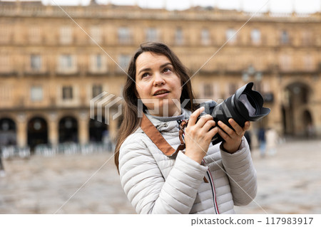Woman photographer with camera capturing architecture of Plaza Mayor in Salamanca 117983917