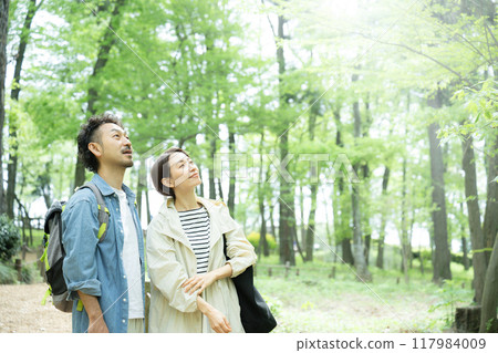 A couple traveling in spring and summer with beautiful fresh greenery, looking up A couple traveling in spring and summer with beautiful fresh greenery, looking up 117984009