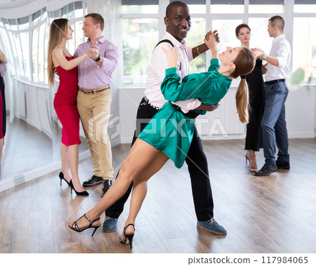Woman dances incendiary tango with African man partner during choreography lesson 117984065