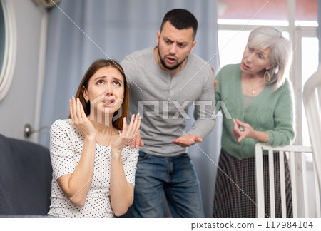 Domestic quarrel - husband and mother try to calm crying wife Domestic quarrel - husband and mother try to calm crying wife 117984104