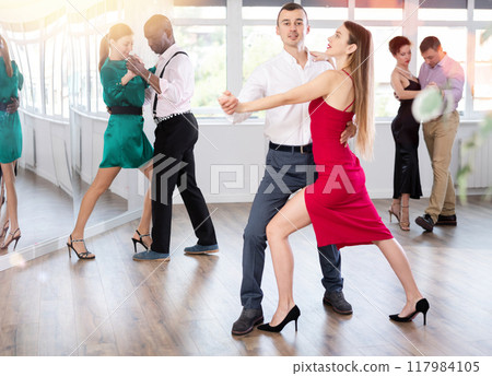 Couples dancing tango, enjoying dance moves in dance salon 117984105