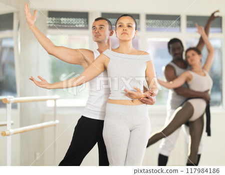 Amateur ballet partners mastering paired technique at group class 117984186