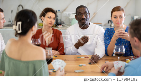 Multiethnic women and men friends playing poker 117984192