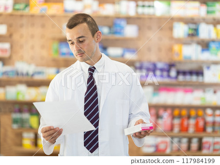 Male pharmacist with medical prescription in hands. 117984199