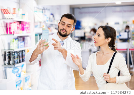 Pharmacist consulting woman buyer about drug Pharmacist consulting woman buyer about drug 117984273
