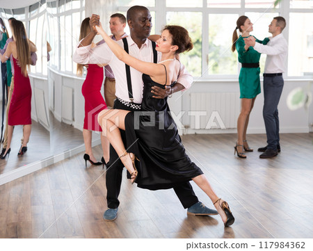 Woman dances incendiary tango with African man partner during choreography lesson 117984362