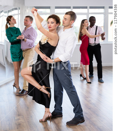 Woman and young man practicing waltz in dancing studio 117984386