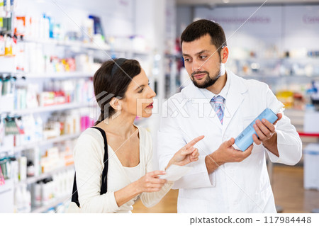 Apothecary giving advise about medicine to woman 117984448