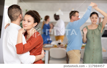 Happy middle-aged men and women doing slow dance in pairs Happy middle-aged men and women doing slow dance in pairs 117984457