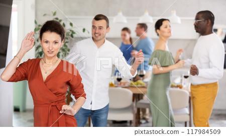 Happy middle-aged men and women doing quick dance in pairs Happy middle-aged men and women doing quick dance in pairs 117984509