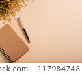 Notebook and pen on a beige background decorated with mimosas 117984748