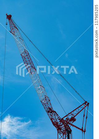 A view of tower cranes constructing a high-rise building against the blue sky 117985205