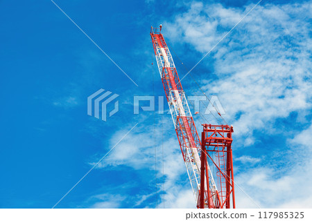 A view of tower cranes constructing a high-rise building against the blue sky 117985325