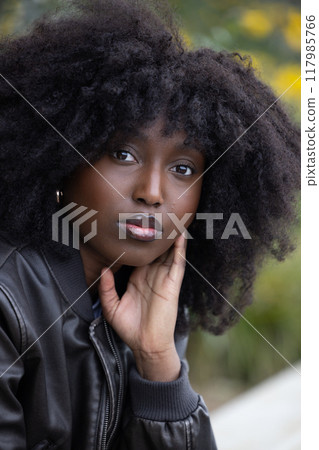 Portrait of a woman in a leather jacket, in a serene forest, with a classic and stylish vibe Portrait of a woman in a leather jacket, in a serene forest, with a classic and stylish vibe 117985766