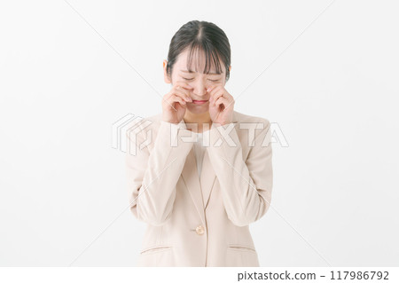 A young woman posing as if she is crying A young woman posing as if she is crying 117986792