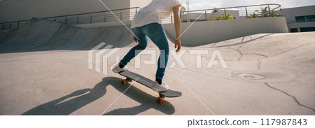 Skateboarder skateboarding at skatepark in city 117987843