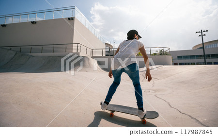 Skateboarder skateboarding at skatepark in city Skateboarder skateboarding at skatepark in city 117987845