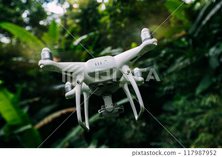 White drone with camera flying in summer mountains White drone with camera flying in summer mountains 117987952