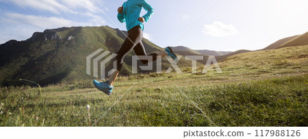 Young woman ultramarathon runner running at mountain top Young woman ultramarathon runner running at mountain top 117988126
