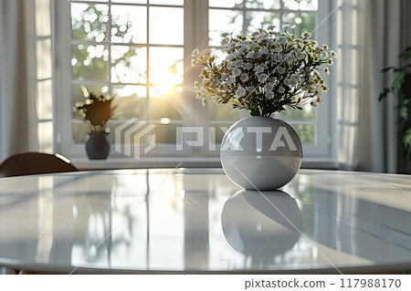 White vase with flowers on table in front of window. Sunlight is shining through the window, casting warm glow. Concept of calm and serenity 117988170