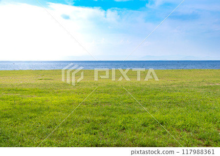 A waterside park with a wide lawn 117988361
