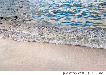 Waves splashing and crashing on the sandy beach 117988364
