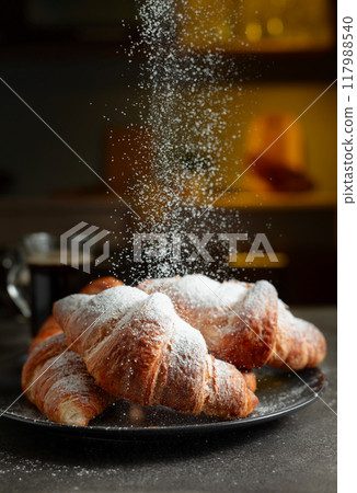 Croissants sprinkled with sugar powder. 117988540