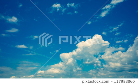 Cumulus clouds and contrails floating in the late summer blue sky: Warm colors 117988860