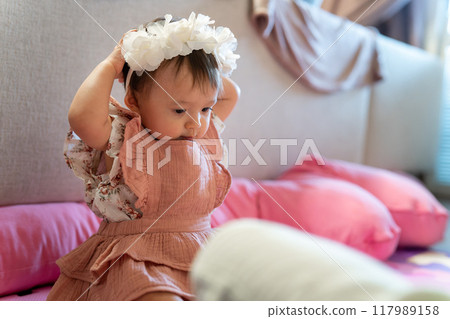 Cute 1-year-old child wearing a flower crown Cute 1-year-old child wearing a flower crown 117989158