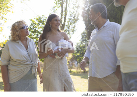 Happy multi generation family walking and talking in the park Happy multi generation family walking and talking in the park 117990190