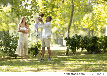 Young family enjoying a sunny day at the park Young family enjoying a sunny day at the park 117990211
