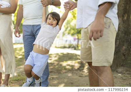 Happy family walking together in the park on a sunny day Happy family walking together in the park on a sunny day 117990234