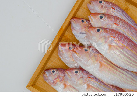 Colorful fish on a wooden tray 117990520