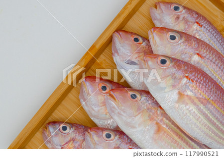Colorful fish on a wooden tray 117990521