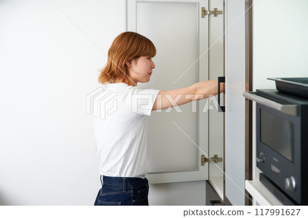 Woman opening cupboard, housework, cooking, life Woman opening cupboard, housework, cooking, life 117991627