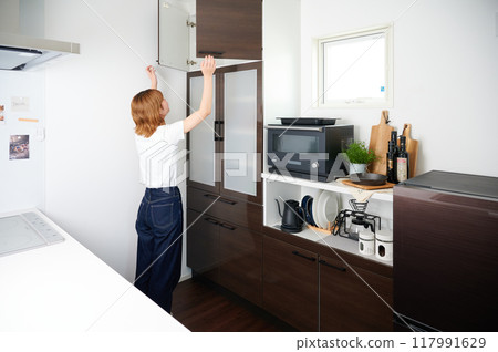 女人打開櫥櫃、家事、烹飪、生活 女人打開櫥櫃、家事、烹飪、生活 117991629