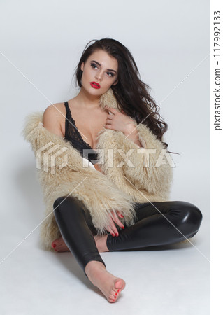 Gorgeous sensual brunette woman with long hair wearing black leather pants, high heels Gorgeous sensual brunette woman with long hair wearing black leather pants, high heels 117992133