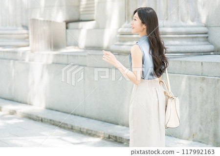 走在辦公區的女商人，後面視圖 117992163