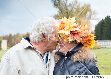 Outdoor portrait of smiling senior couple in autumn park Outdoor portrait of smiling senior couple in autumn park 117992292