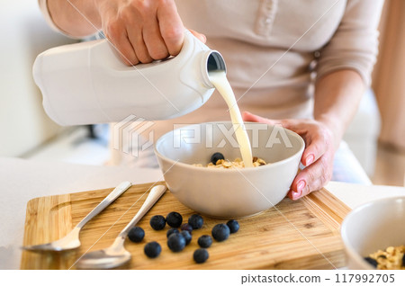 Girl preparing morning breakfast with oatmeal 117992705