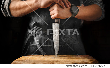 Chief man holding knife at kitchen Chief man holding knife at kitchen 117992749