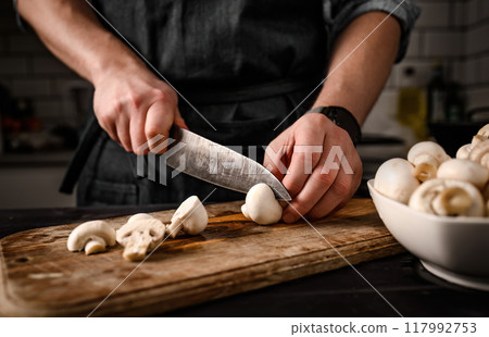 Chief hands cutting shampignons with knife 117992753
