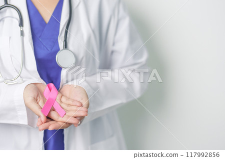 Pink October Breast Cancer Awareness month, woman doctor with pink Ribbon in hospital for support people life and illness. National cancer survivors month, Mother and World cancer day concept 117992856