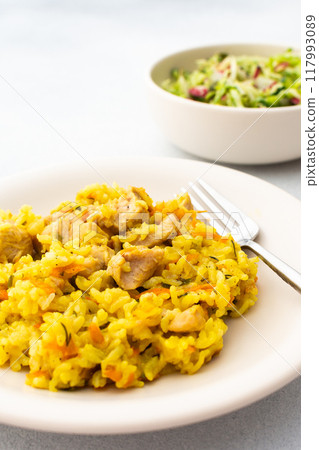 Stewed rice with chicken breast and mixed salad with radishes and various seeds 117993089